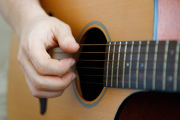 Close-up of a male hand playing a guitar. Learning music. Fun, live music.