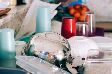 Clean dishes that have been hand washed and are now sitting on the counter to dry and waiting for someone to do their household chores and not be lazy