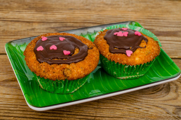 Homemade cakes. Two delicious vanilla sweet muffins with chocolate icing.