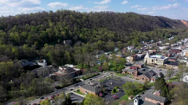 Aerial turning shot to the left showing Berkeley Springs, WV with views of hotels, state park, castle and shops.