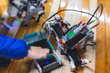 Group of children kids playing with robotic vehicle model, science lesson, making and programming a handmade robot, robotics projects, fun and development