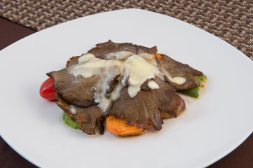 Slightly fried vegetables over high heat in boiling oil in the lower layer, and on top of stewed mushrooms in sour cream sauce.