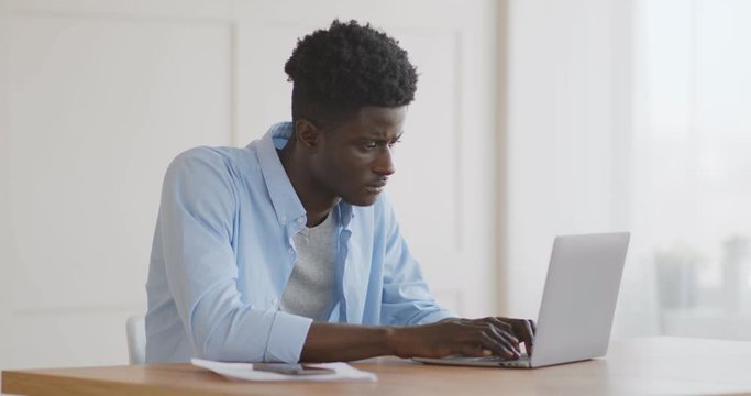 Upset african american man having issues with laptop