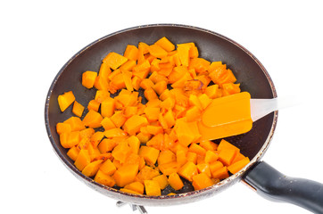 Fried slices of orange nutmeg pumpkin in pan.