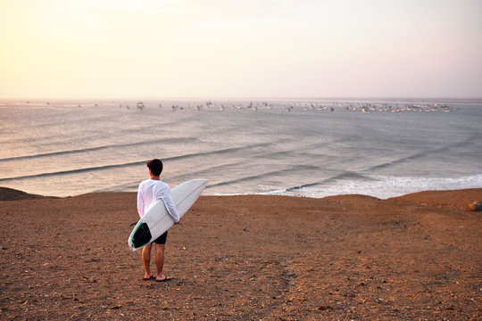 A surfer overlooks the empty waves at Chicama