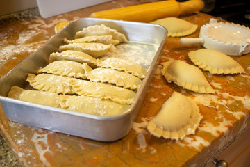 Preparation of mini pies (empanada) with rolling pin and flour around