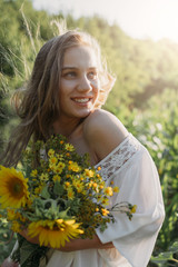 Naklejka premium Slow living, digital detox, happiness is in small things concept. Lifestyle portrait of beautiful girl who enjoys nature and flowers in the field in sunlight