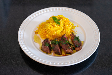 Carrot risotto with parmesan cheese and basil and filet mignon medallion. Home made food from...