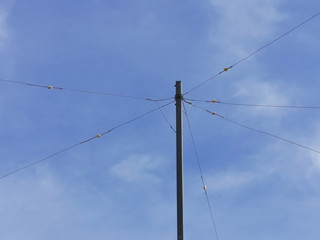 pole with electrical wires against a blue sky
