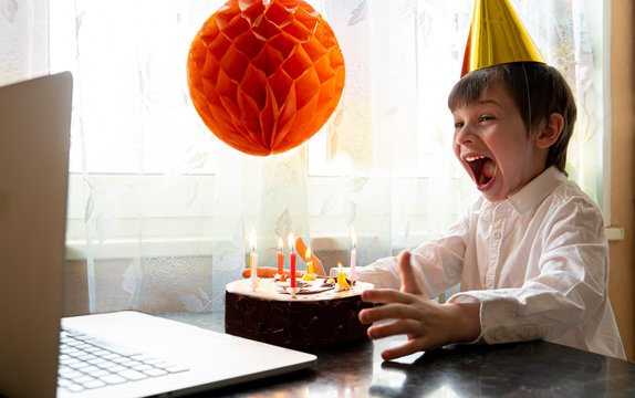 Cheerful boy in mask celebrates his birthday remotely during quarantine