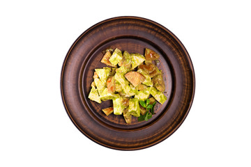 Georgian vegetable salad with tomatoes, cucumber and onions seasoned with walnut sauce in a white bowl. Salad in a composition with ingredients.