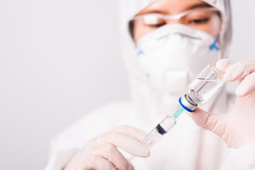 doctor or scientist in PPE suite uniform in lab hold medicine liquid vaccine vial bottle and syringe