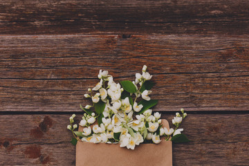 Fototapeta na wymiar Jasmine flowers in an envelope on a wooden background.