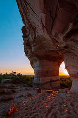 Sunset view through the rock, colorful arenite, contrasting with green vegetations and blue sky in Pedra furada tourist attraction, Jalapao, Brazil.
