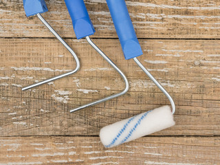 Paint rollers and handles on wooden background.