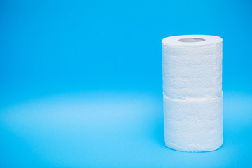 Rolls of white toilet paper on blue background