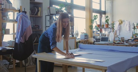 Young woman cutting fabric