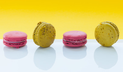 A french sweet delicacy, macaroons variety closeup. Macaroon colourful, different types of macaroons on a white and yellow background