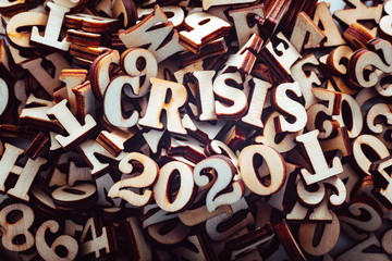 Stack of macro wooden letterpress letters with the text economic crisis in 2020.
