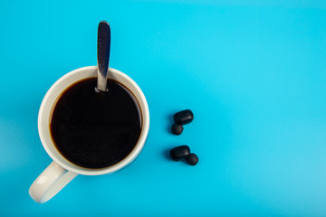 Top view Coffee and smartphone with Wireless bluetooth headphones on a blue background 