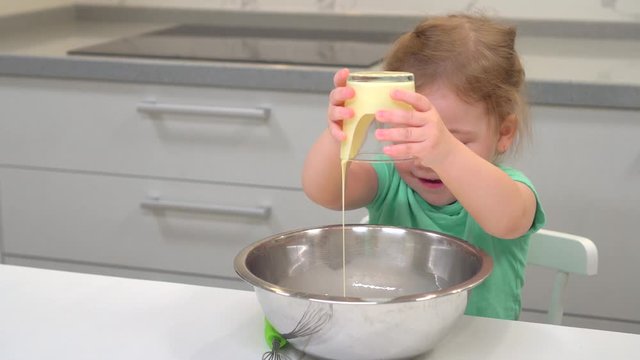a little girl pours condensed milk into the cake cream