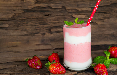 Strawberry yogurt fruit juice smoothie pink colorful fruit juice milkshake blend beverage healthy high protein the taste yummy In glass drink episode morning on wood background.