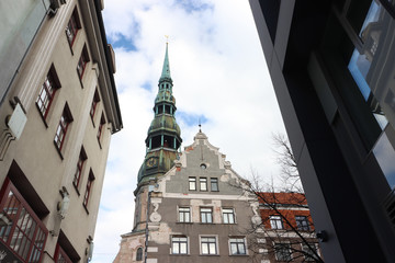 View of the tower of St. Peter's Church in Riga and the old house, Latvia