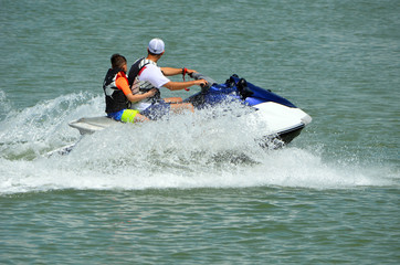 Man and a young boy riding tandem on a jet ski