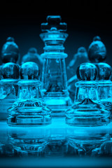 Glass chess pieces surrounding the King