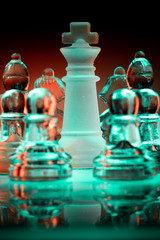 Obraz premium Glass chess pieces surrounding the King