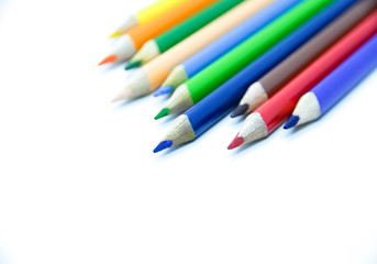 Photo of arrangement of color pencils isolated on white background. Blank space for text. Flat lay. Close up. Top view. Leadership business concept. School concept. Rainbow color pencil.