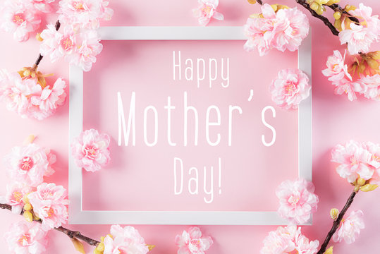 Happy Mother's Day, Women's Day or Valentine's Day greeting concept. Pastel Pink Colours Background with picture frame and blossom flowers flat lay patterns.