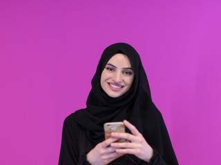 muslim business woman using smartphone on pink background