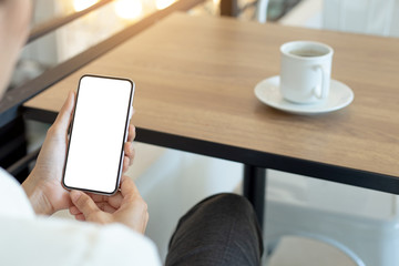 cell phone Mockup image blank white screen.woman hand holding texting using mobile on desk at coffee shop.background empty space for advertise text.people contact marketing business,technolog