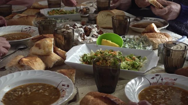 Crowded Turkish muslim family having a dinner together around a table eating food
