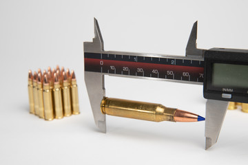 Caliper used to measure length of cartridge after seating bullet into brass during reloading or making ammunition for gun, pistol or rifle. - obrazy, fototapety, plakaty