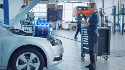 Female Mechanic Uses a Tablet Computer with an Augmented Reality Diagnostics Software. Specialist Inspecting Car's V6 Engine in Order to Find Broken Components. Hi-tech Modern Car Service. - Powered by Adobe