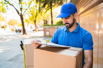 Delivery man carrying package outdoors.