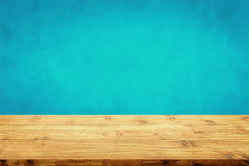 Empty wood table with blurred blue wall background.