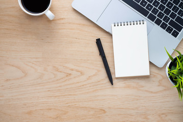 Workplace in office with wood desk. Top view from above of keyboard with notebook and coffee. Space for modern creative work of designer. Flat lay with blank copy space. Business and finance concept.