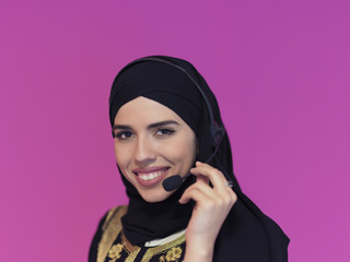 portrait of muslim woman with headset on pink background