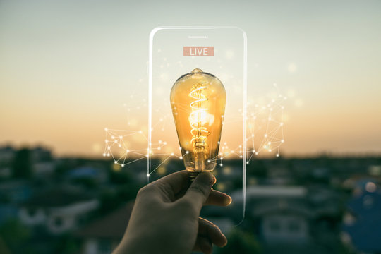 Hand business man holding light bulb with lighting frame of mobile phone and Live text. Alternative energy, idea, saving electricity innovation and inspiration concepts.