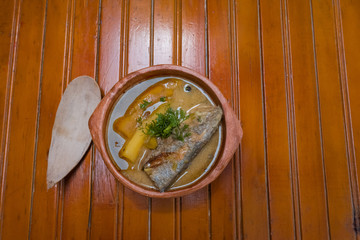 Delicious fish soup with coriander up close in a bowl on the table. Colombian food