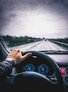 Cropped Hand Driving Car During Rainy Season