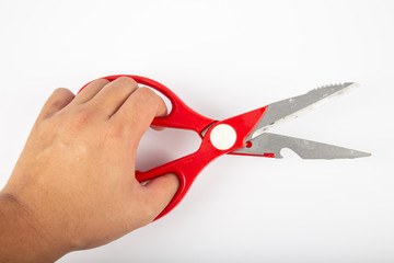 Man hand with Scissors with red plastic handles, on a white background.