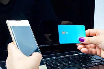 woman holding a golden cell phone with a blue card on top of a notebook