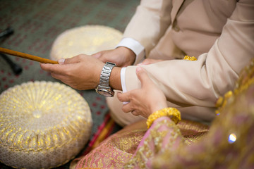 Bride holding arms of groom at wedding Thailand