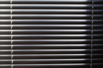 Horizontal blinds. Sunlight coming through venetian blinds by the window.