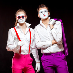 Portrait of male mime artists, isolated on black background. Two man are posing adjusting...