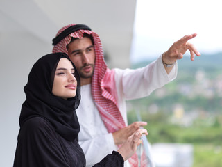 portrait of beautiful arabian couple standing on balcony
